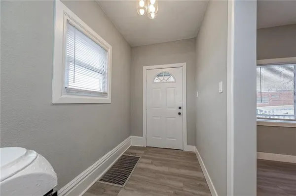 a view of a room with wooden floor and windows