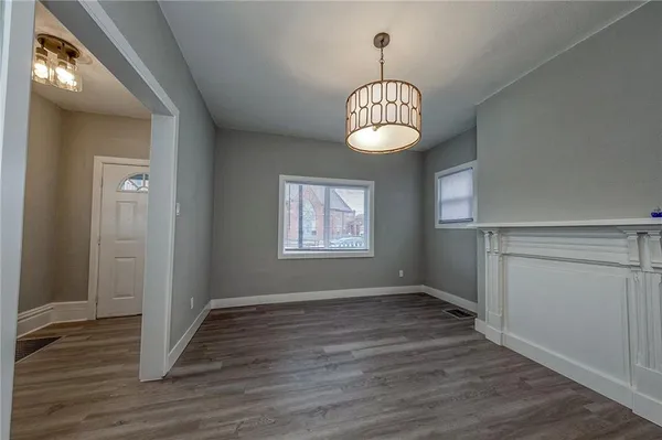 an empty room with wooden floor and window