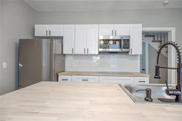 a kitchen with stainless steel appliances granite countertop a refrigerator and a sink