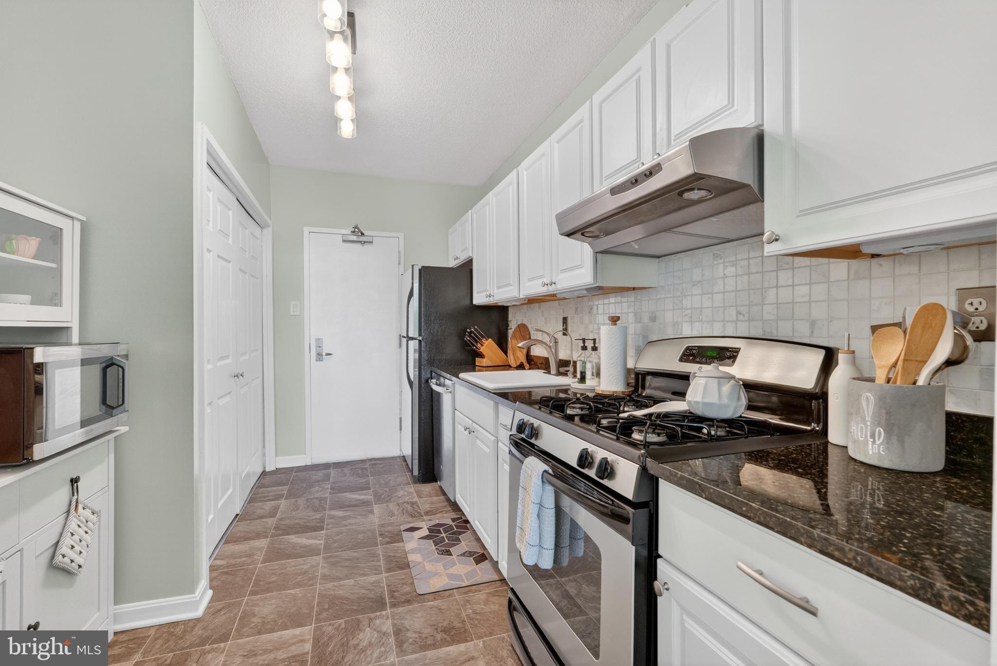 4141 North Henderson Road, Unit 302 Arlington, VA 22203 - Photo 11 of 40 a kitchen with stainless steel appliances granite countertop a stove and a sink