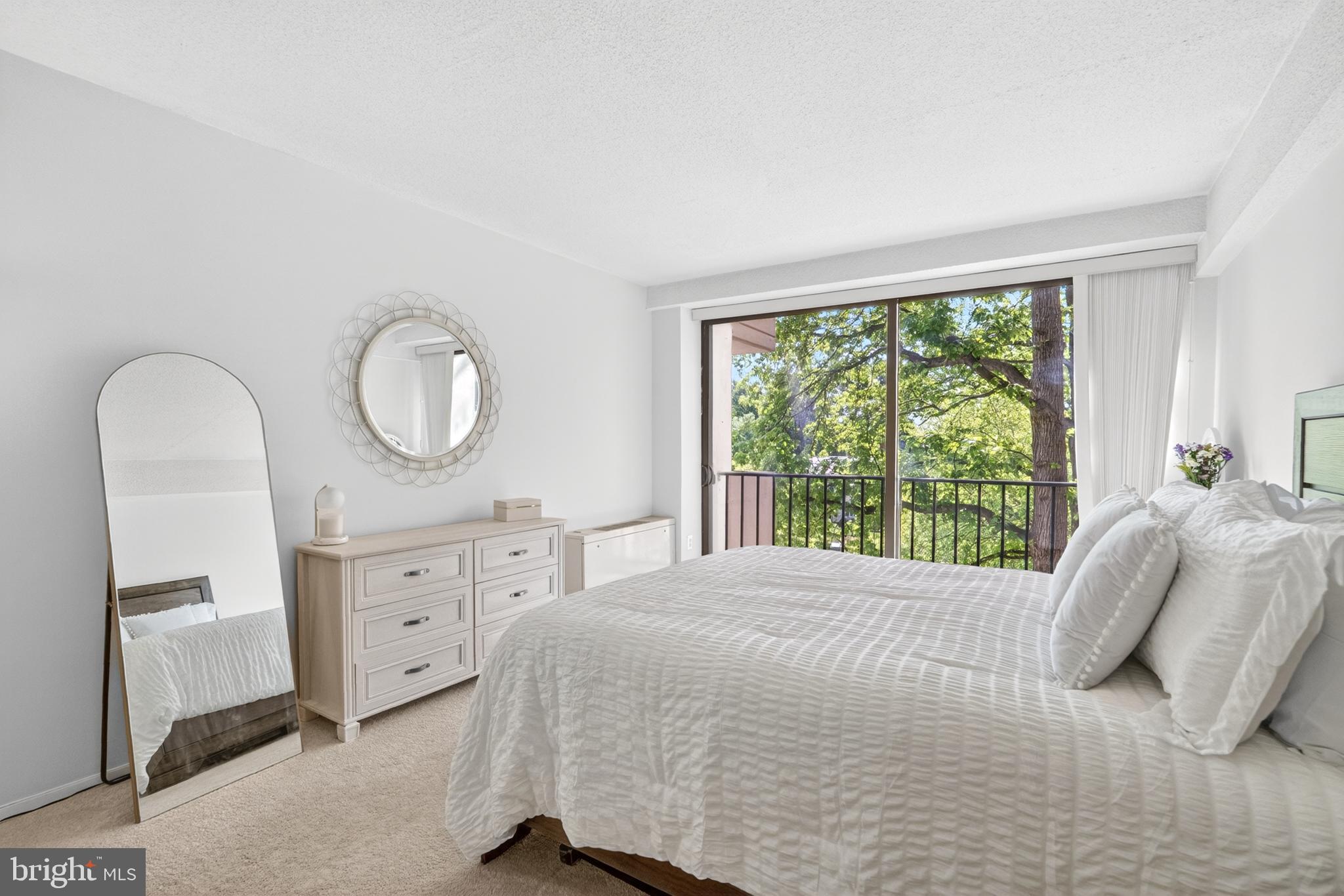4141 North Henderson Road, Unit 302 Arlington, VA 22203 - Photo 15 of 40 a bedroom with a bed windows and a chandelier