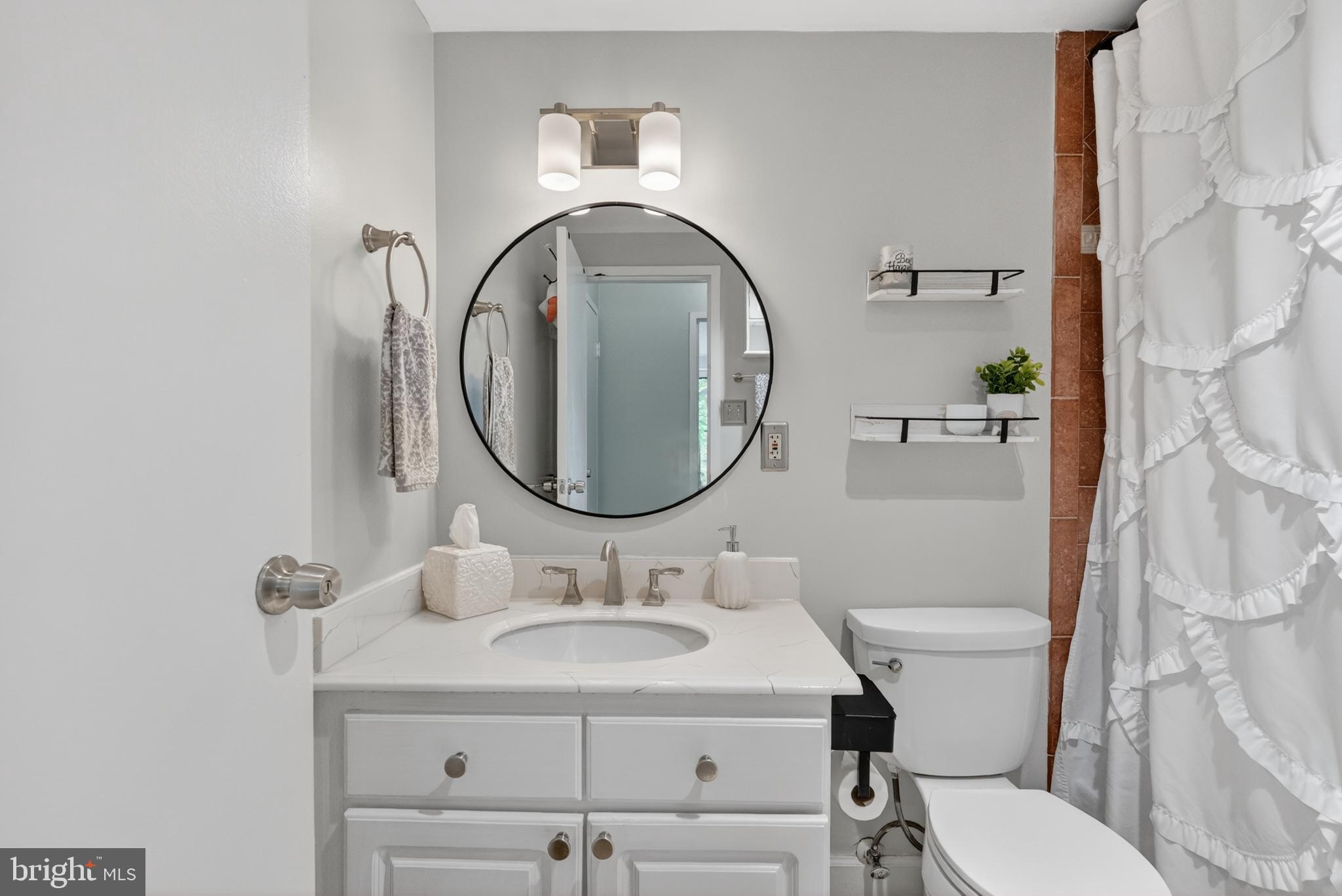 4141 North Henderson Road, Unit 302 Arlington, VA 22203 - Photo 17 of 40 a bathroom with a sink toilet and a mirror