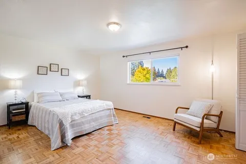 a bedroom with a bed and painting on the wall