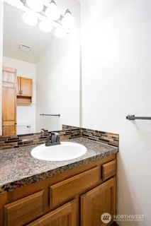a bathroom with a granite countertop sink and a mirror