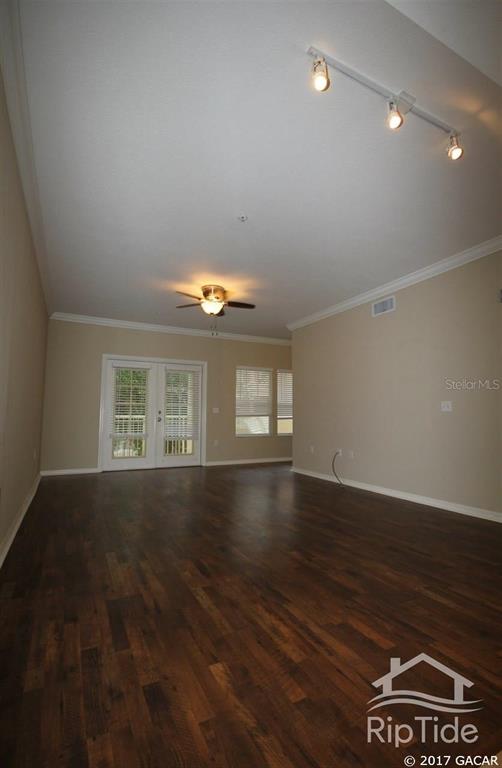 9158 Southwest 51st Road, Unit J202 Gainesville, FL 32608 - Photo 1 of 1 an empty room with wooden floor and windows