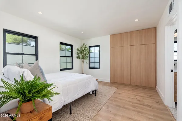 a bedroom with a bed table and chair