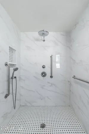 a bedroom with a large bed and a chandelier