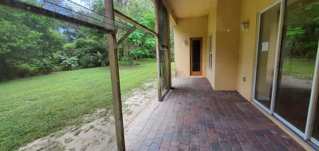 a view of a porch with wooden floor and a yard