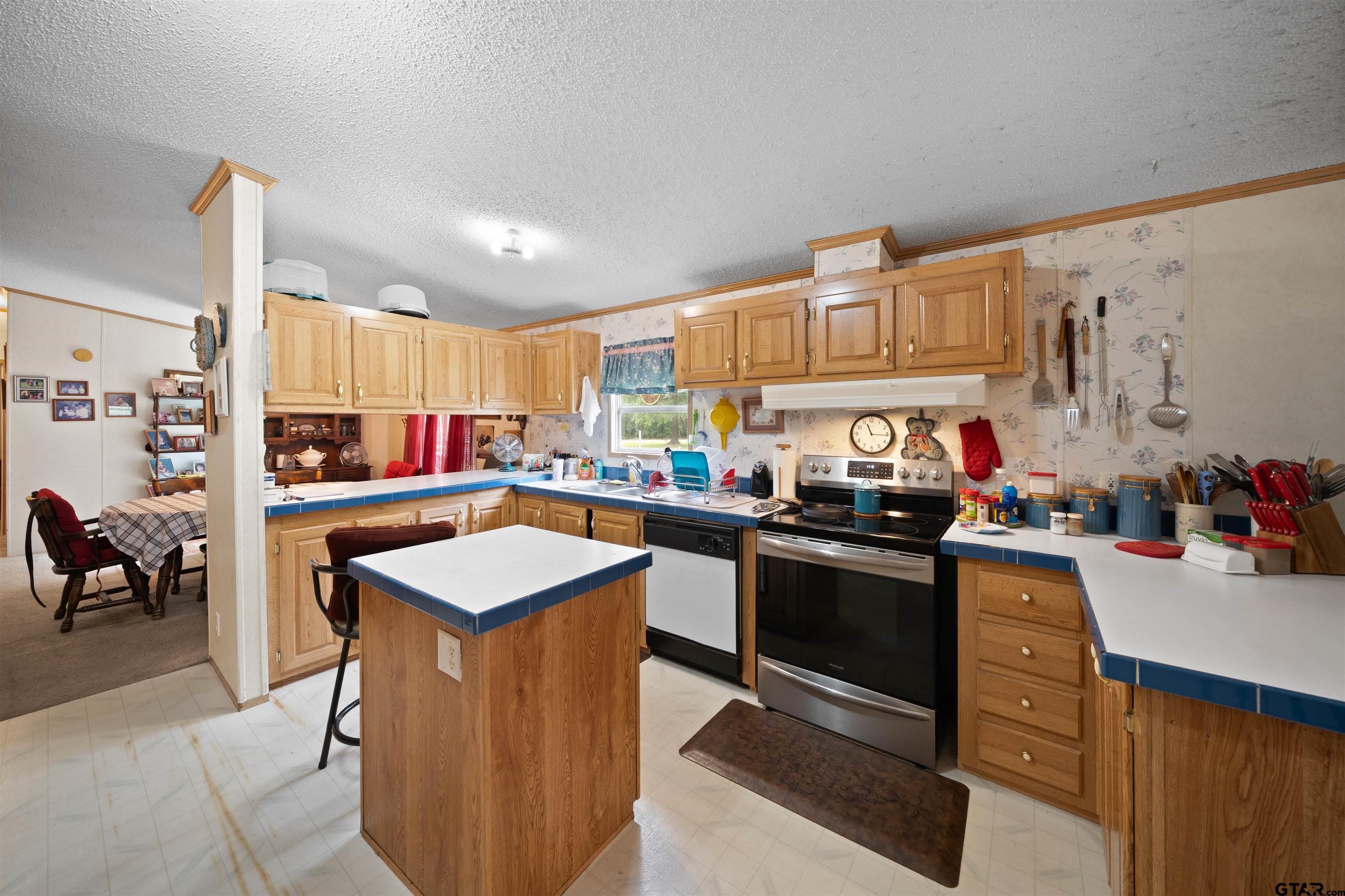 2425 Thompson Lane Tyler, TX 75704 - Photo 11 of 27 a kitchen that has a lot of cabinets in it and wooden floors