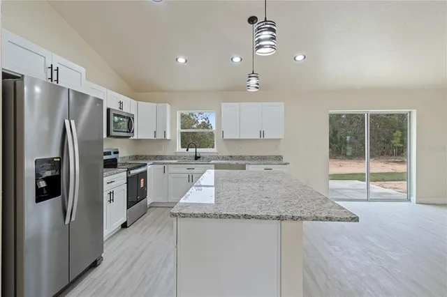 a kitchen with refrigerator cabinets and wooden floor