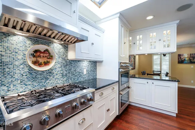 a kitchen with stainless steel appliances a stove a sink and a refrigerator