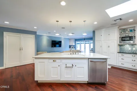 a kitchen with stainless steel appliances granite countertop a stove and a wooden floors