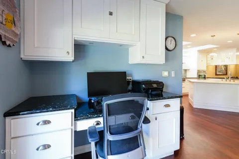 a kitchen with stainless steel appliances a stove a sink cabinets and a wooden floor