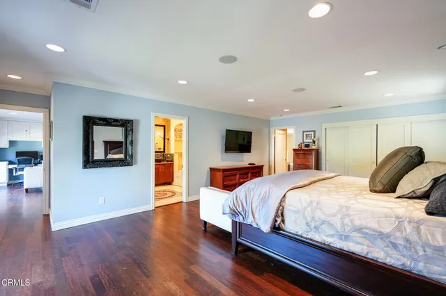 a bedroom with a large bed and a tv