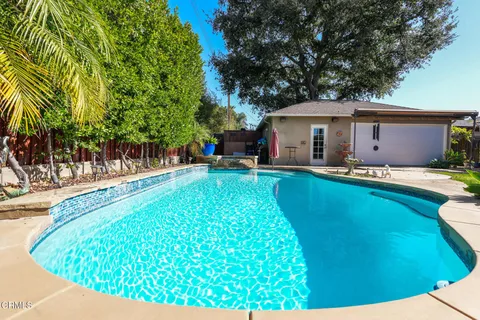 a swimming pool with outdoor seating and yard