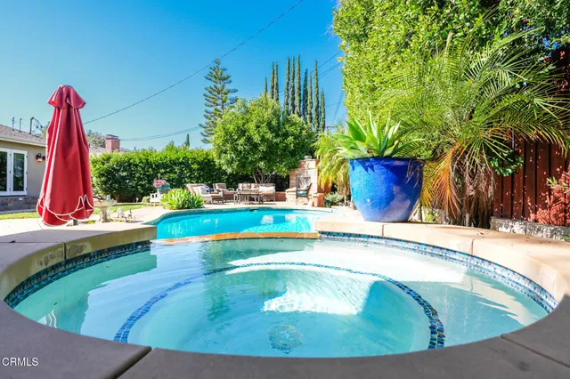 a view of a swimming pool with a potted plants and wooden fence
