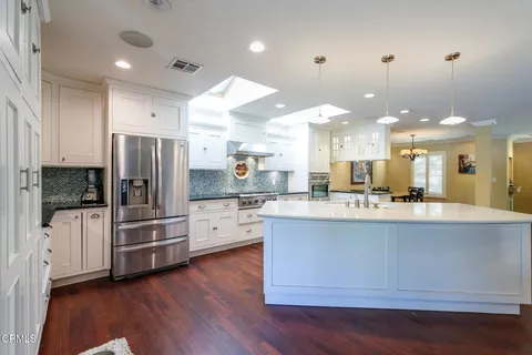 a large kitchen with stainless steel appliances kitchen island a large counter top and a stove