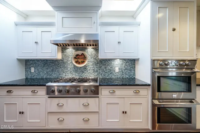 a kitchen with white cabinets and appliances