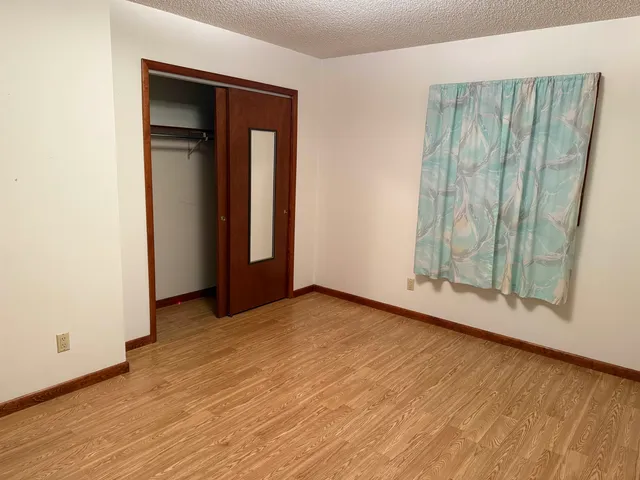 an empty room with wooden floor and entrance