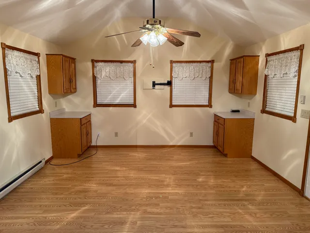 a view of an empty room with window and cabinet