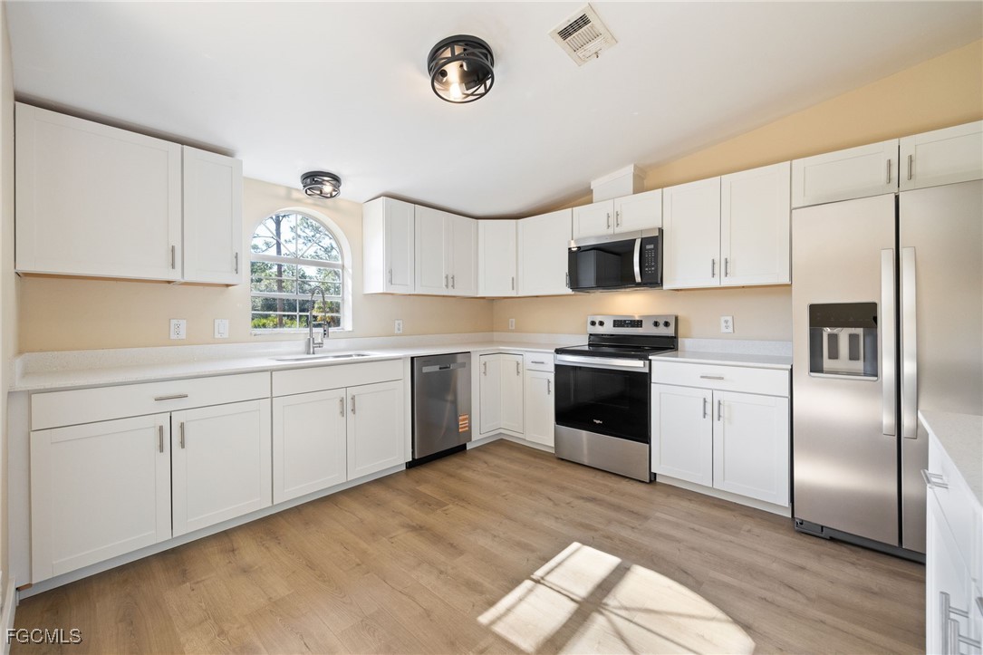 250 Trader Road LaBelle, FL 33935 - Photo 12 of 42 a kitchen with a white cabinets and white appliances