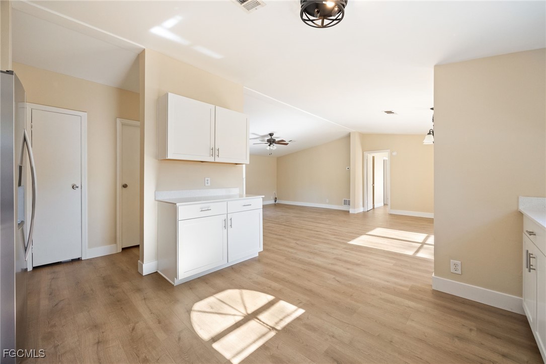 250 Trader Road LaBelle, FL 33935 - Photo 13 of 42 a kitchen with granite countertop a stove a sink and white cabinets with wooden floor