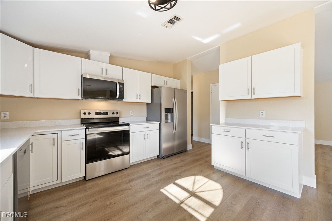250 Trader Road LaBelle, FL 33935 - Photo 14 of 42 a kitchen with granite countertop a sink cabinets and stainless steel appliances