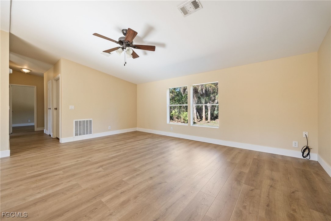 250 Trader Road LaBelle, FL 33935 - Photo 17 of 42 an empty room with wooden floor chandelier fan and windows