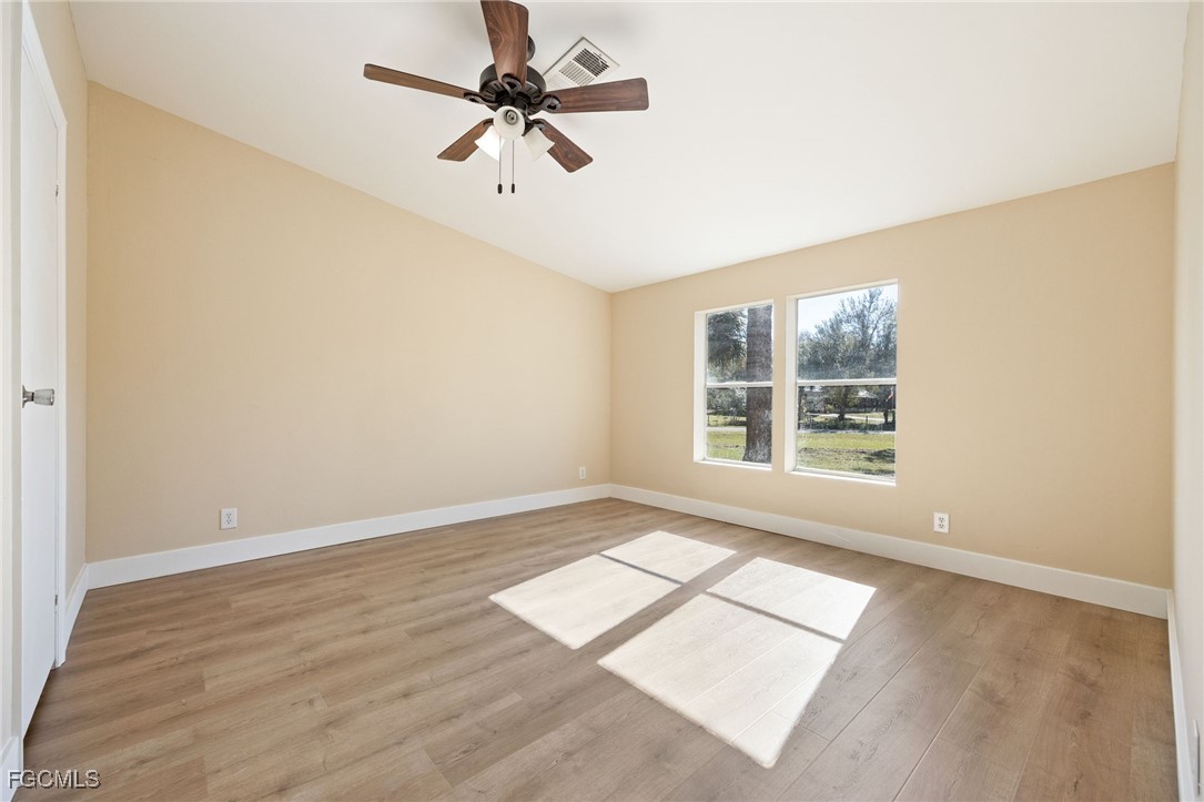 250 Trader Road LaBelle, FL 33935 - Photo 21 of 42 an empty room with wooden floor fan and windows