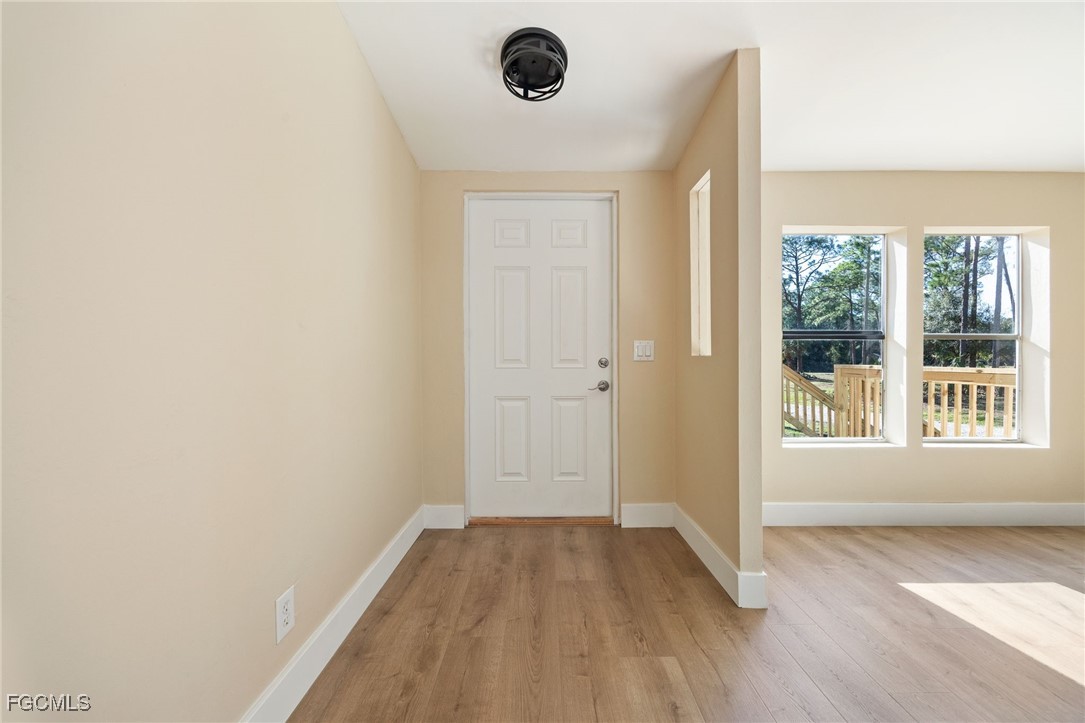 250 Trader Road LaBelle, FL 33935 - Photo 7 of 42 an empty room with wooden floor and windows