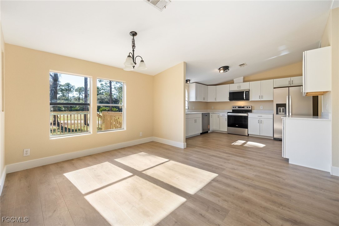 250 Trader Road LaBelle, FL 33935 - Photo 10 of 42 a view of a kitchen with a stove cabinets a refrigerator and wooden floor