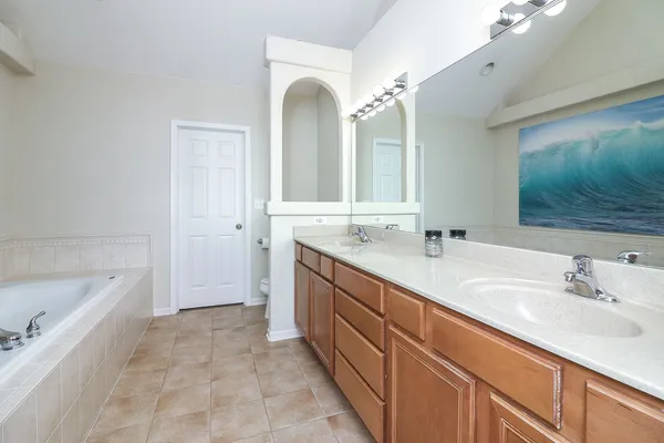 a spacious bathroom with a bathtub sink and mirror