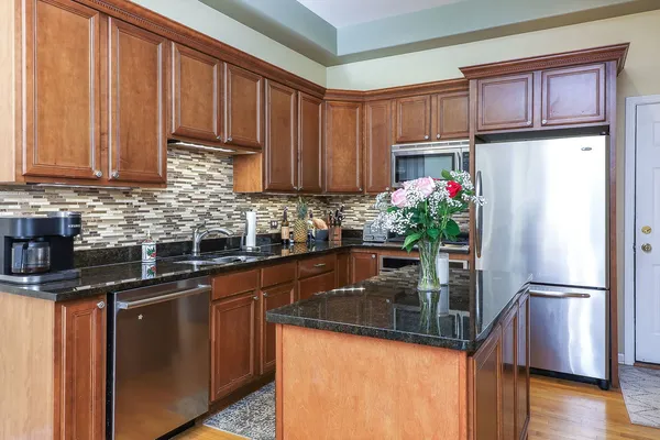 a kitchen with stainless steel appliances granite countertop a refrigerator a sink and a stove
