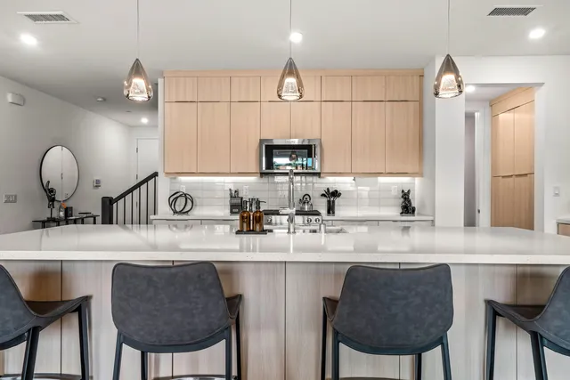 a kitchen with kitchen island granite countertop a sink cabinets and refrigerator
