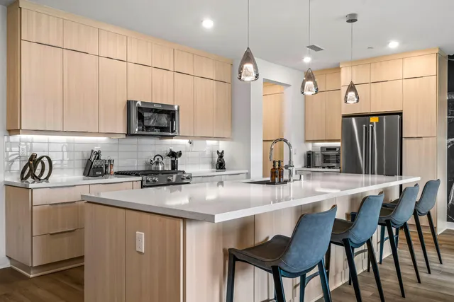 a kitchen with stainless steel appliances granite countertop a stove a sink a refrigerator a microwave and a refrigerator