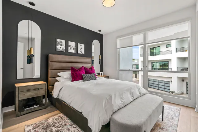 a bed sitting in a bedroom next to a window