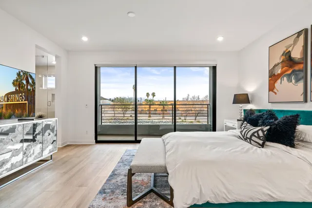 a bedroom with a white bed and dresser