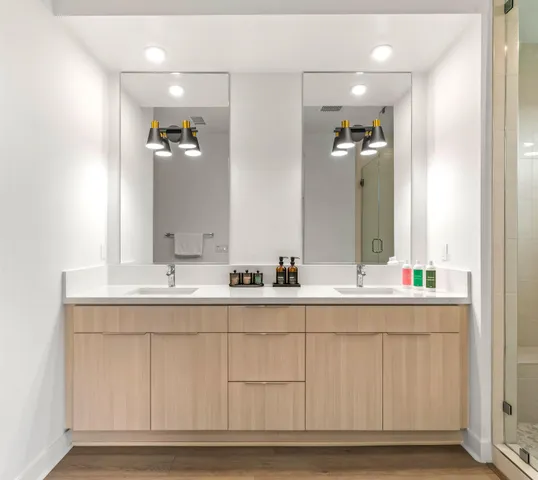 a bathroom with a double vanity sink mirror and shower