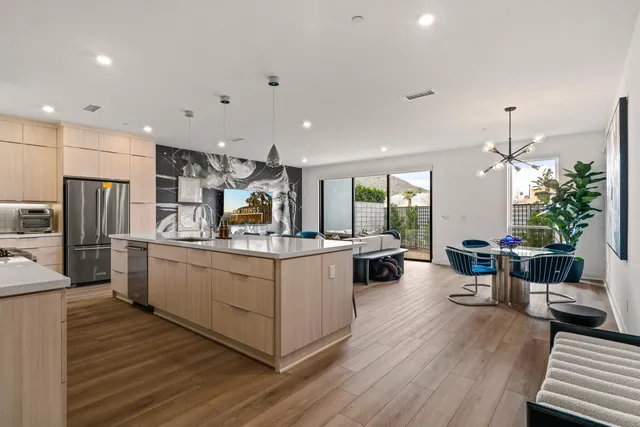 a kitchen with stainless steel appliances kitchen island wooden floors stove and white cabinets