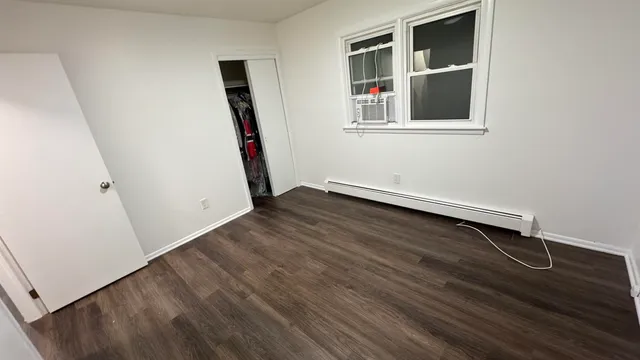 an empty room with wooden floor and entryway