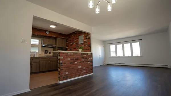 a kitchen with stainless steel appliances wooden floor and a refrigerator