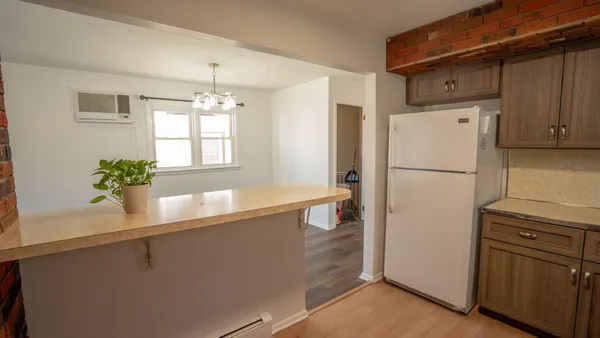 a kitchen with granite countertop a refrigerator a stove a sink and dishwasher with wooden floor