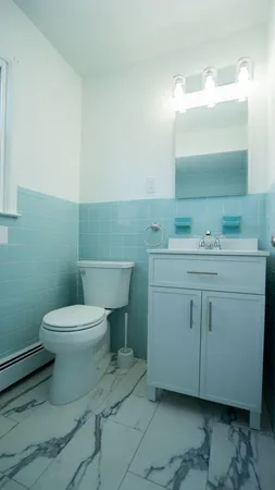 a bathroom with a toilet sink and mirror