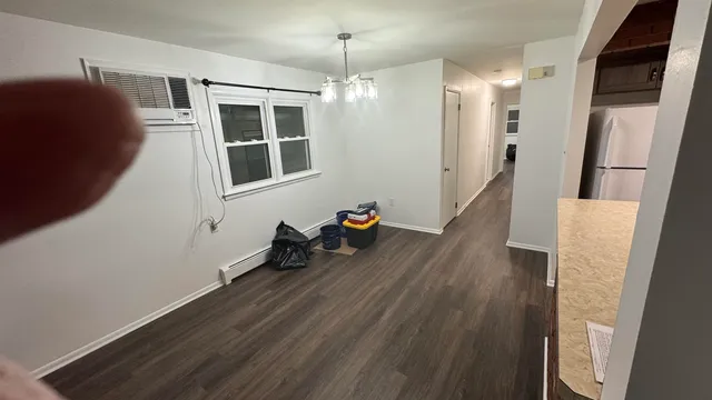 a hallway with wooden floor and chandelier