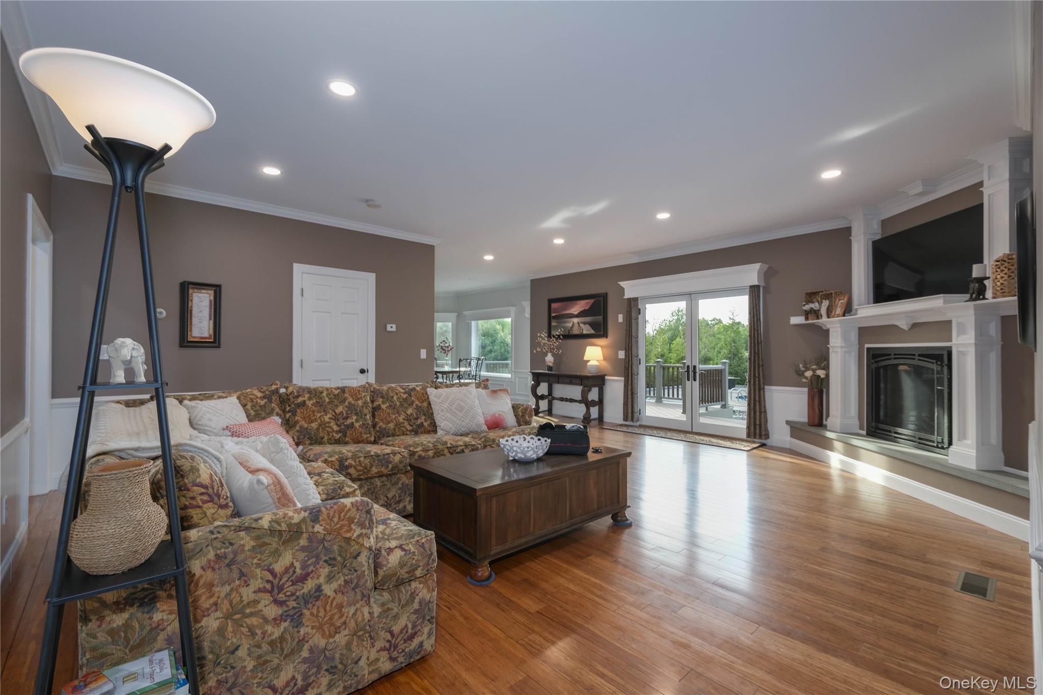 163 Hapeman Hill Road Red Hook, NY 12571 - Photo 10 of 50 Living room with hardwood floors, recessed lighting, crown molding, a gas fireplace, and French doors to deck overlooking the in-ground pool complex.