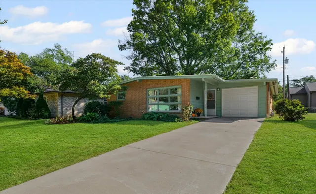 a view of a house with a yard and potted plants