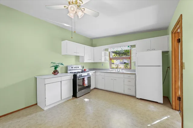 a white kitchen with stove and cabinets