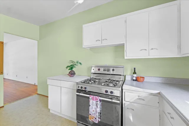 a kitchen with a stove a sink and a window
