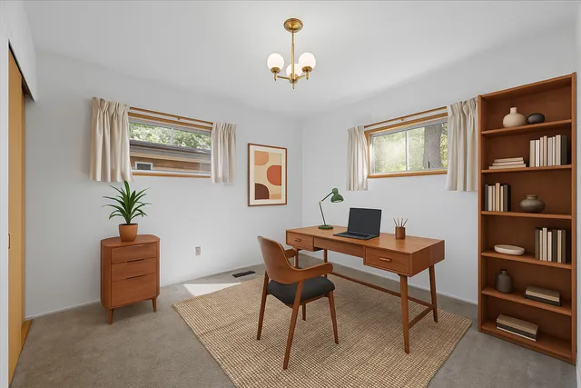 a view of a workspace with lounge chair and a bookshelf