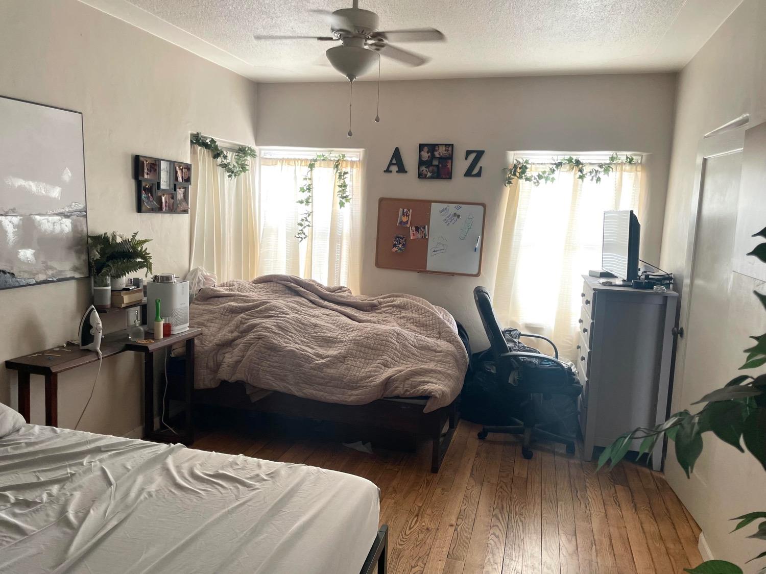 221 North Reed Avenue Reedley, CA 93654 - Photo 6 of 10 a bedroom with a bed and wooden floor